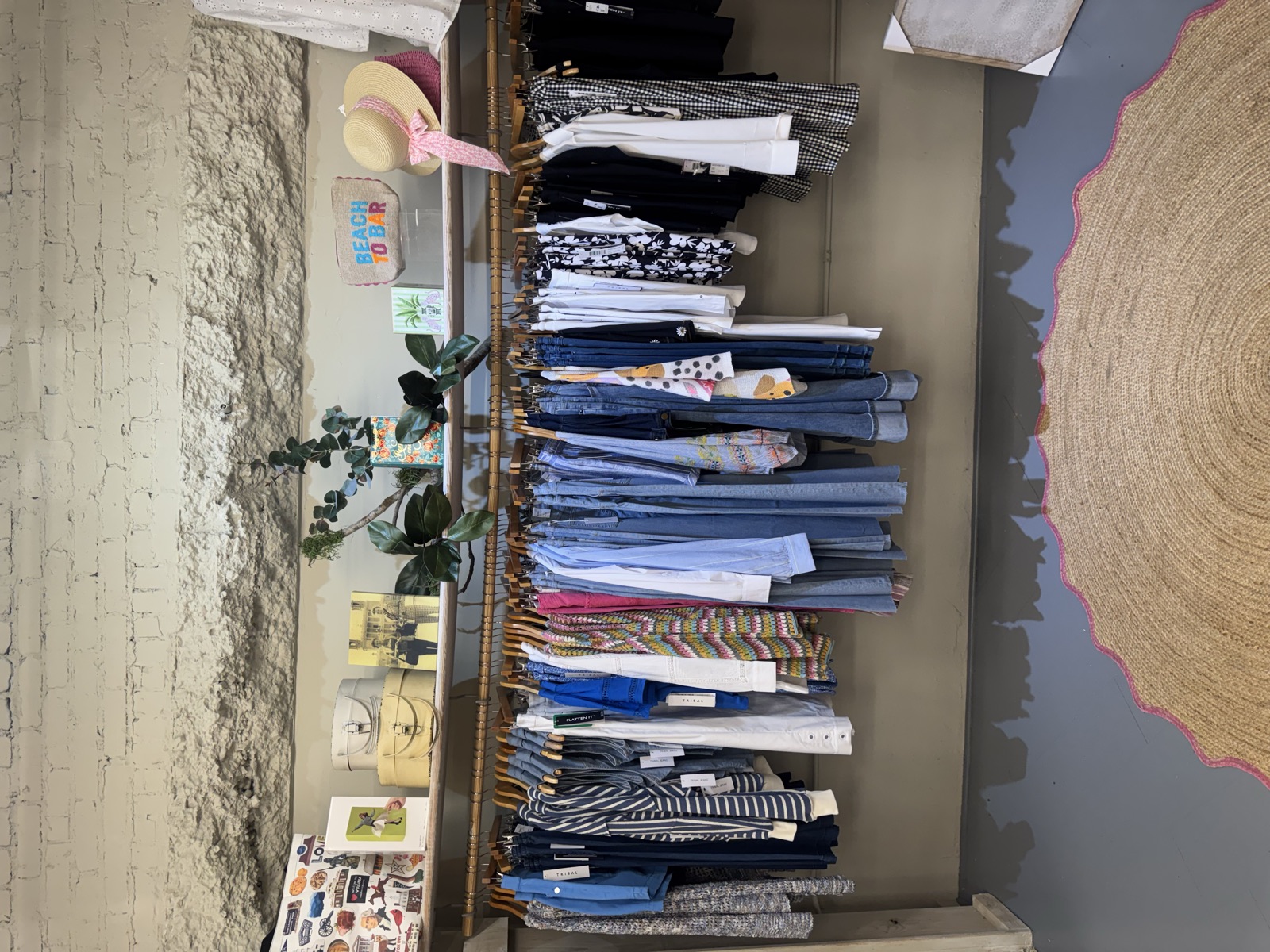 Racks of denim and linen against the shop's whitewashed brick wall